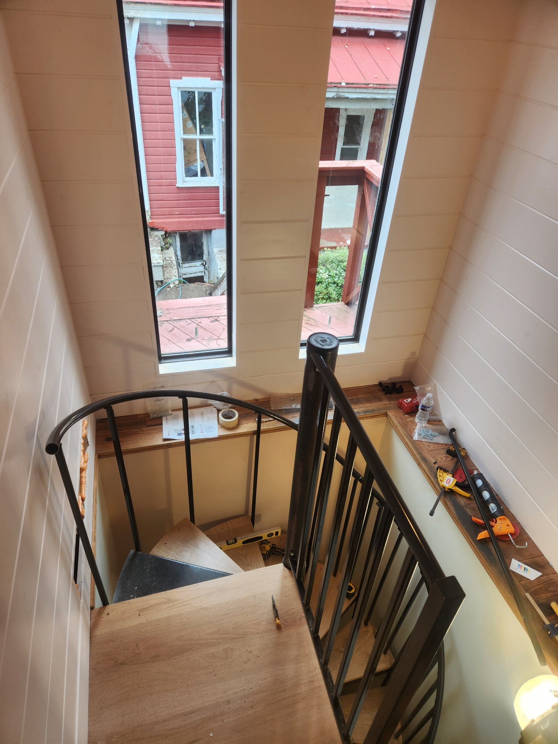 Spiral staircase with black railing and shiplap