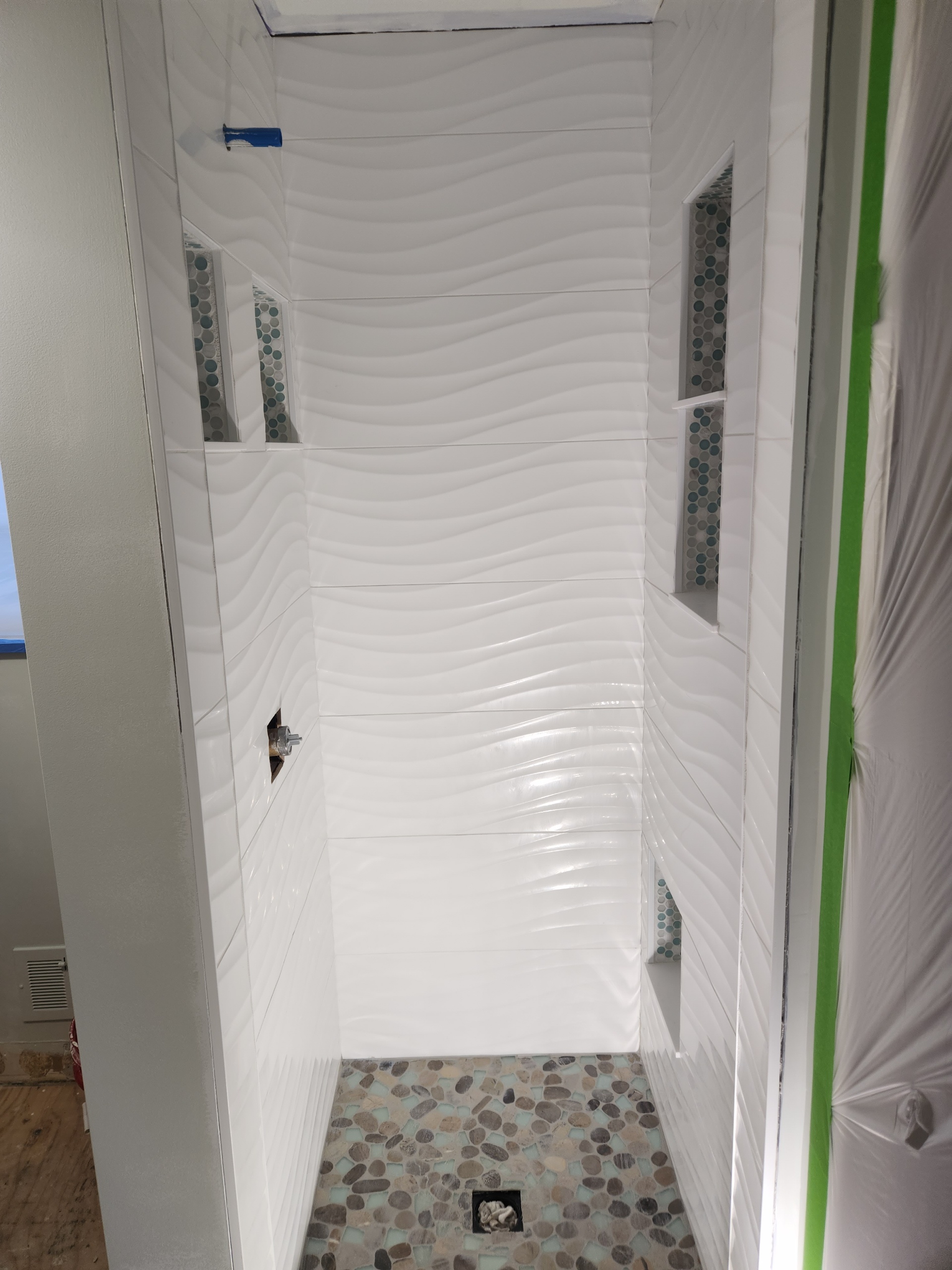 3D white wave tile shower with teal niches
